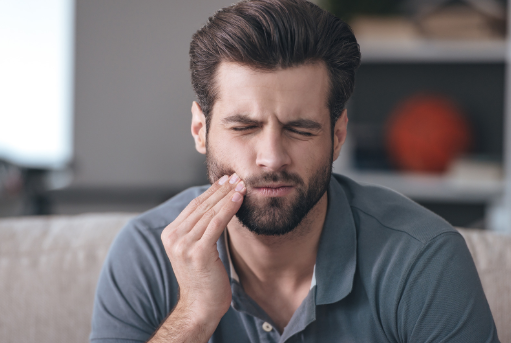 man holding his jaw in pain